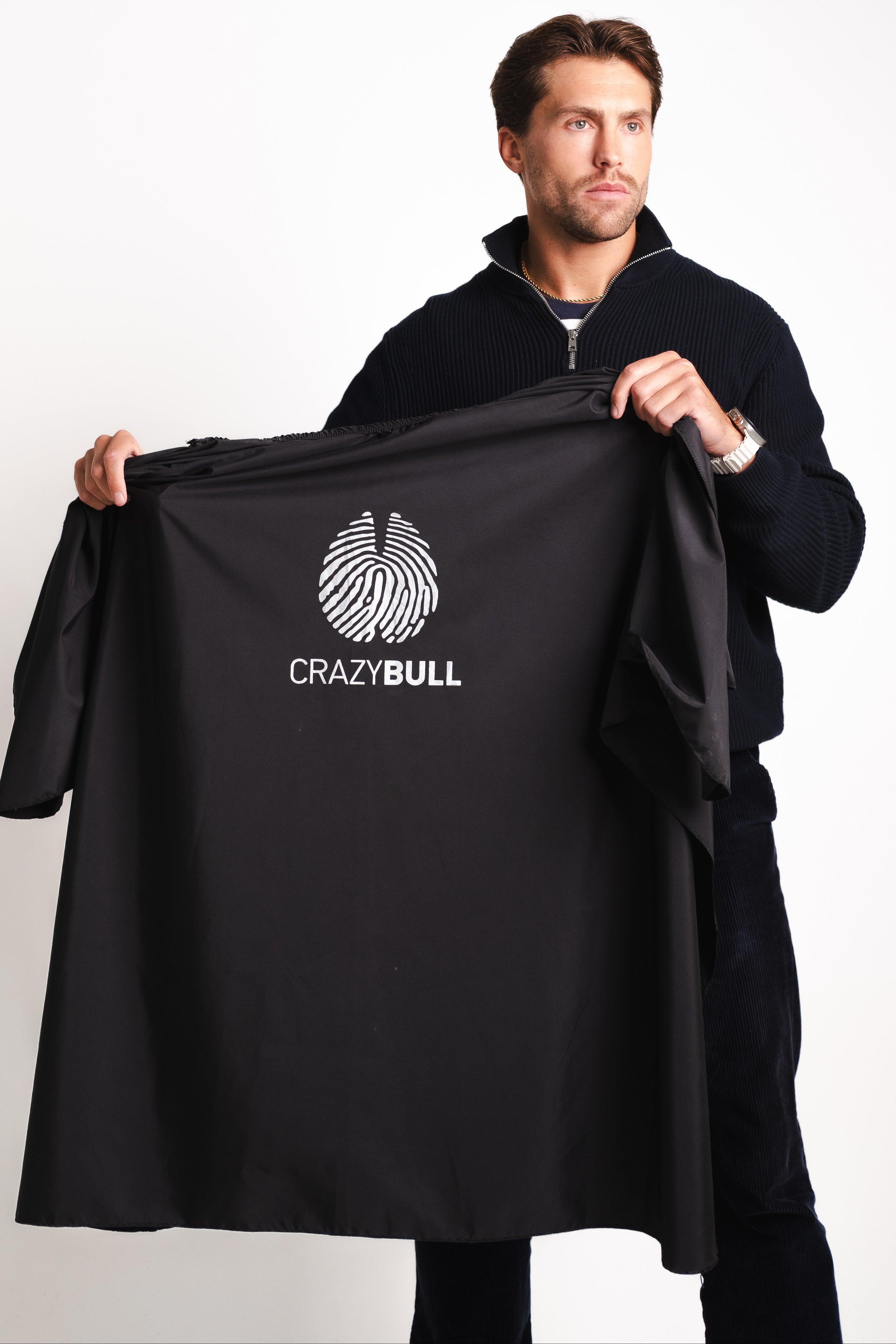 Man holding a black jacket with 'CrazyBull' logo on a white background